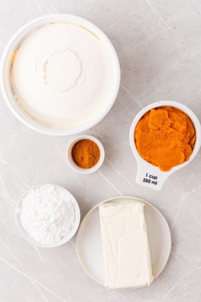 Ingredients needed to make pumpkin dip: Cool Whip, pumpkin puree, pumpkin pie spice, powdered sugar, and cream cheese.