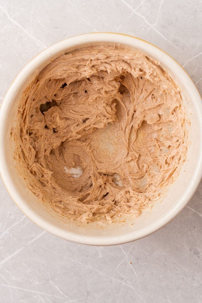 Cream cheese, powdered sugar, and pumpkin pie spice blended in a bowl.