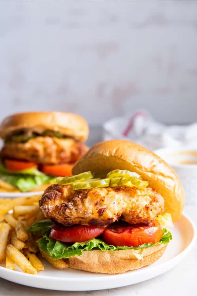 side view of chick fil a fried chicken sandwich with pickles and sauce