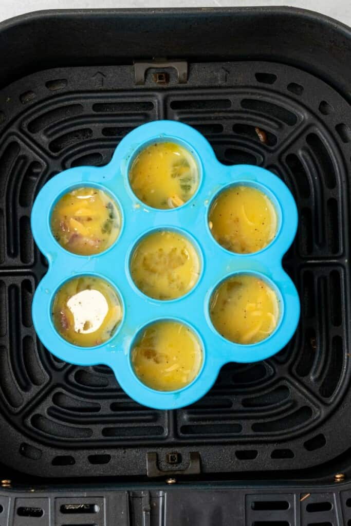 adding egg bite mixture to silicone molds