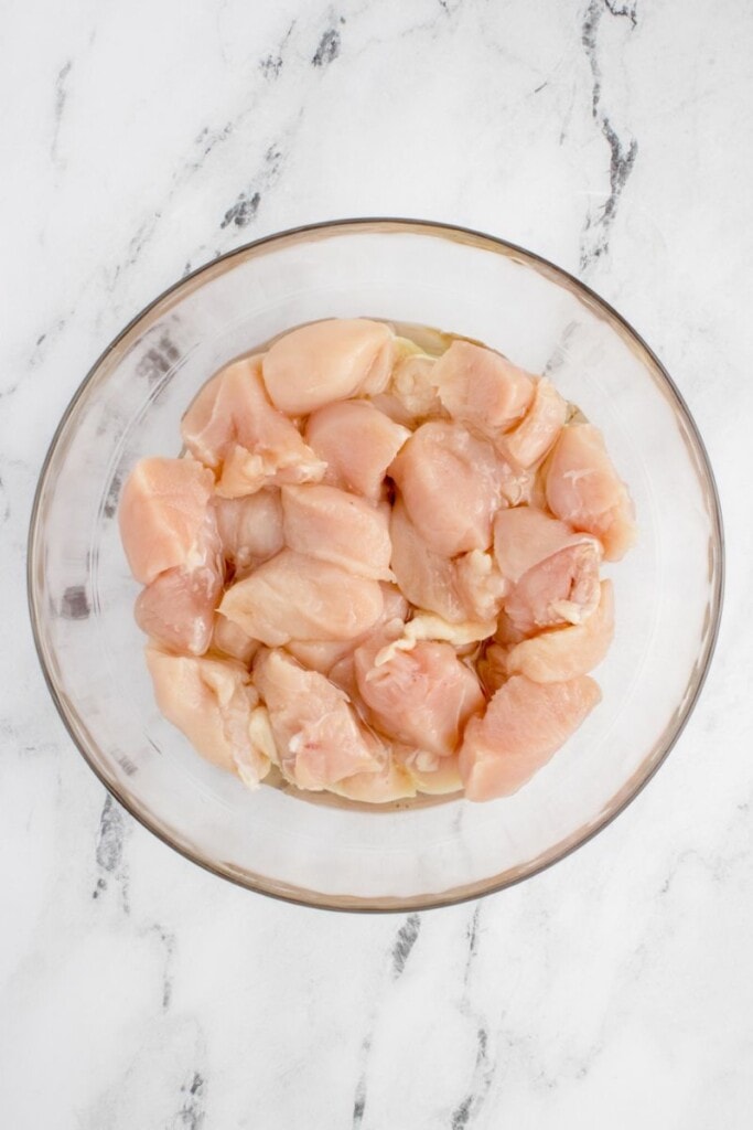 raw diced chicken breasts in a glass bowl 