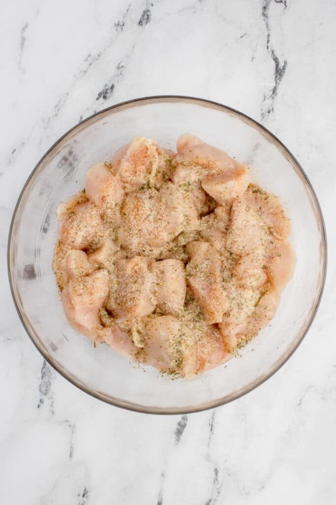 seasoned chicken breasts with olive oil in a bowl 