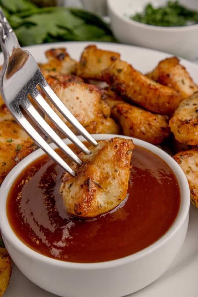 dipping air fryer chicken bites into bbq dipping sauce 