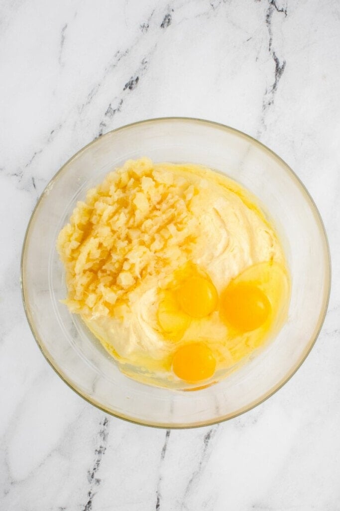 adding crushed pineapples and eggs to cake batter