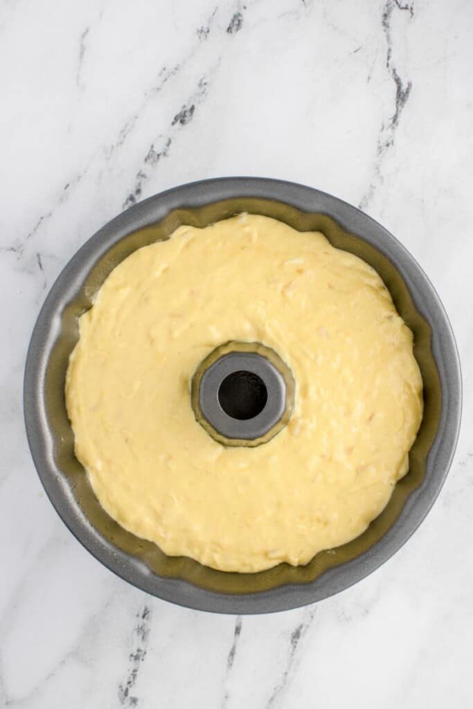 adding pound cake batter to bundt cake pan 