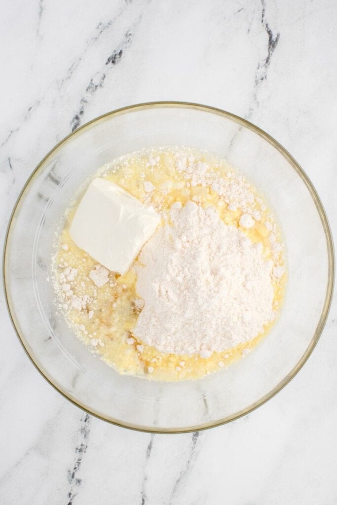 a bowl filled with cream cheese and cake mix 