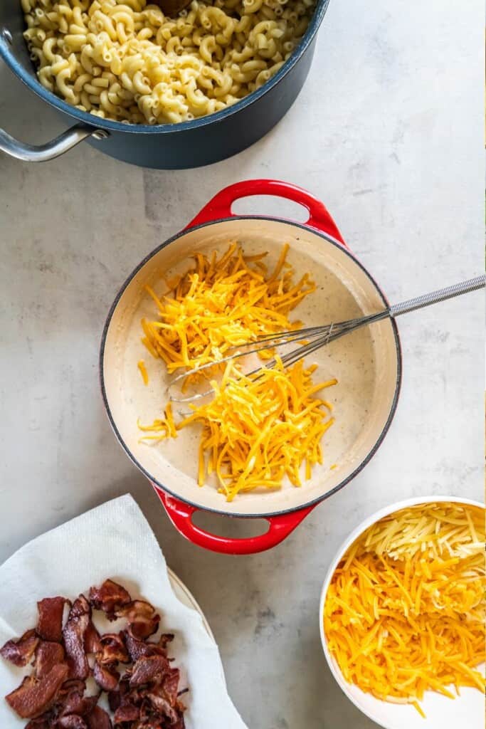 adding in grated cheeses to roux in Dutch oven. 