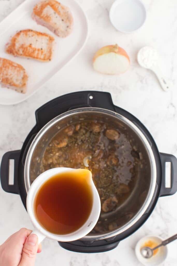 pouring in beef stock to the Instant Pot