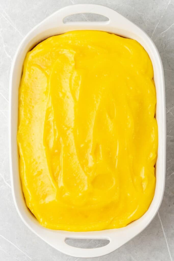 adding a layer of lemon pudding over baked cake