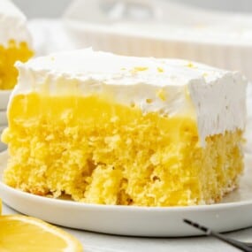 a slice of lemon poke cake on a white plate