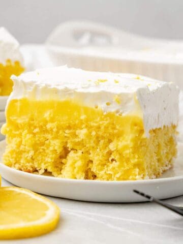 a slice of lemon poke cake on a white plate