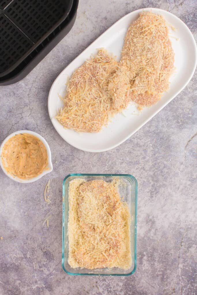 coating chicken breast with shredded parmesan cheese 