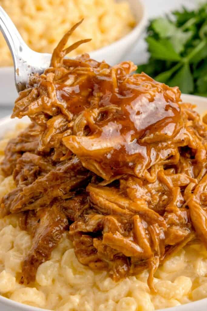 bbq pulled pork piled high on top of macaroni and cheese