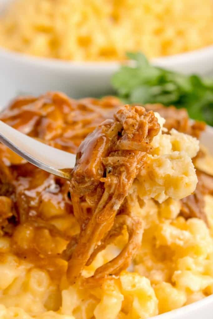 eating a bite of the best pulled pork mac n cheese