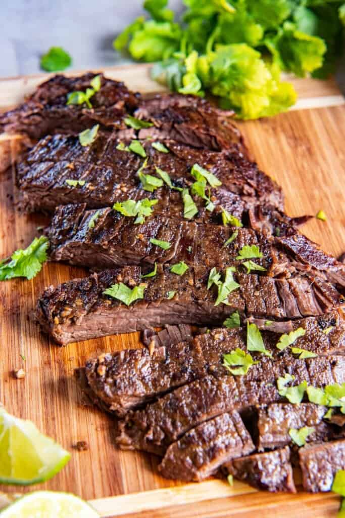 sliced flank steak on a wooden cutting board