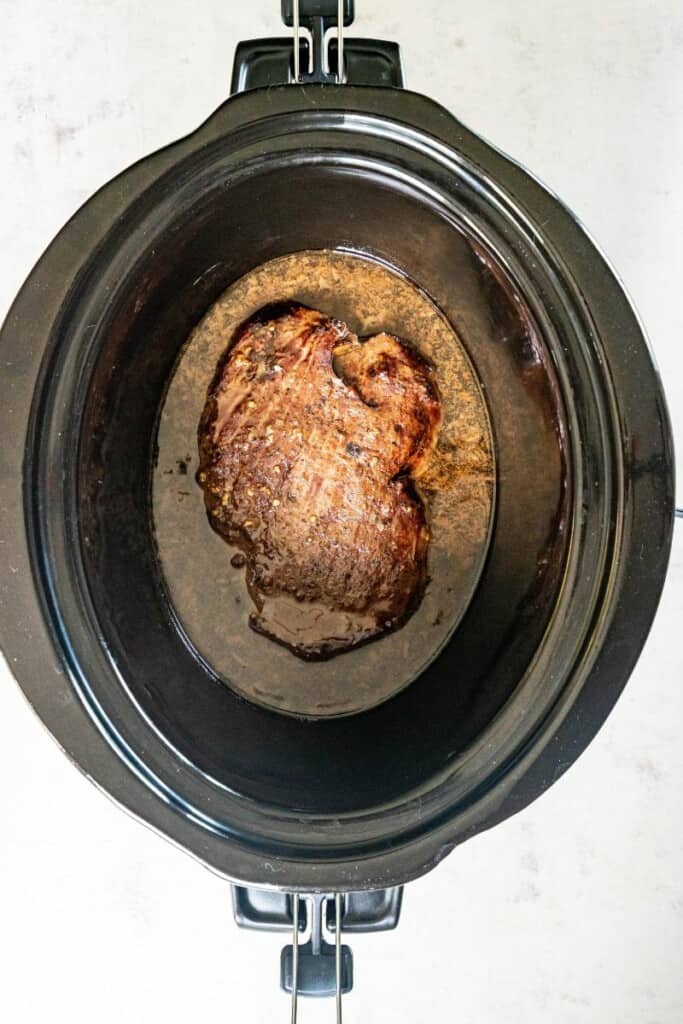 cooked marinated steak in the slow cooker