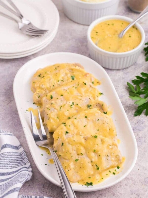Creamy pork chops served on a small platter.