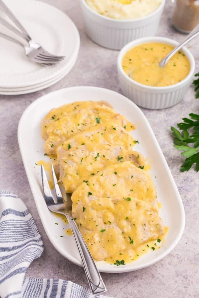 Creamy pork chops served on a small platter.