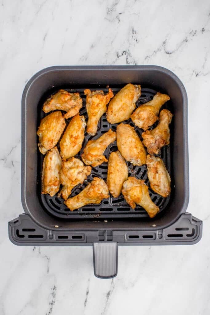 cooked chicken wings in the air fryer basket 