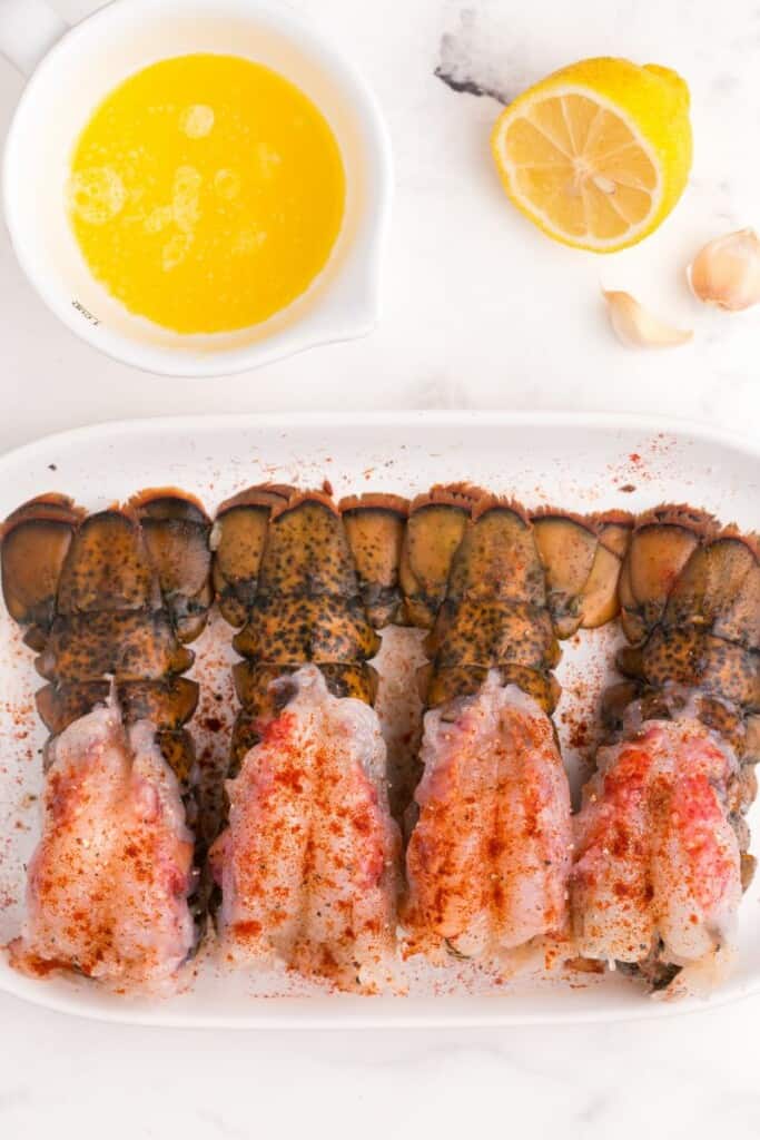 Raw lobster tails on a plate.