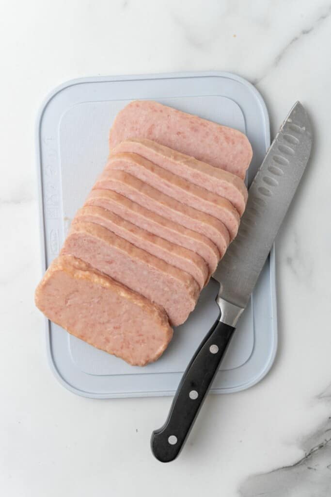 Slices spam on a cutting board.