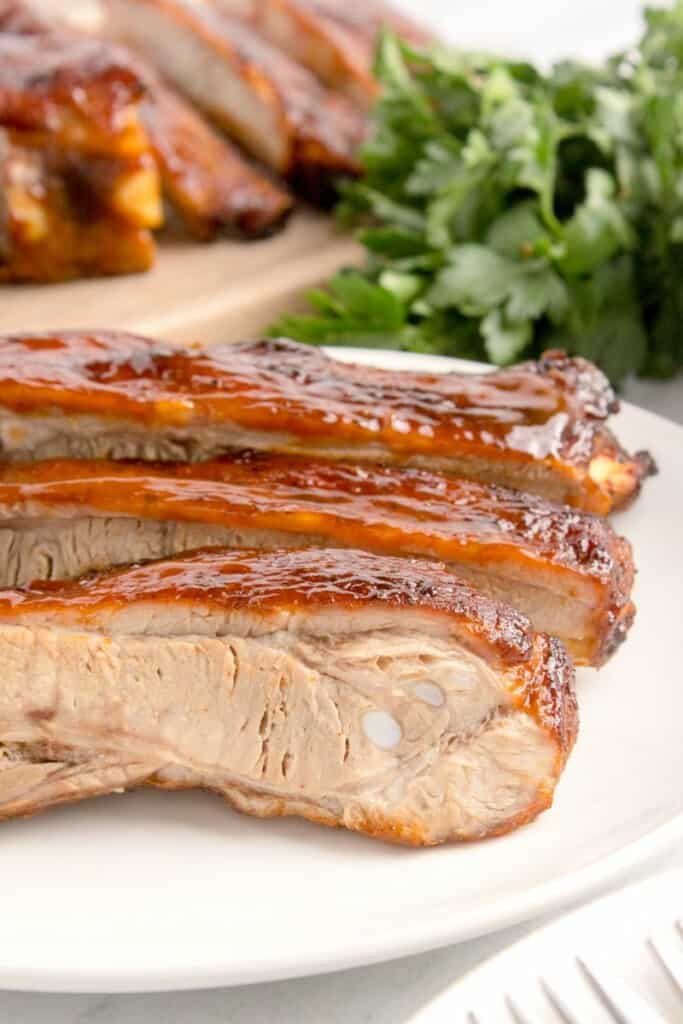 Sliced pork ribs lining a plate.