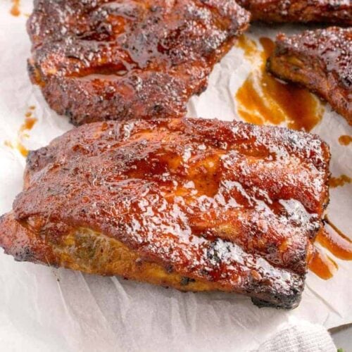 Barbecue glazed pork ribs on parchment paper.