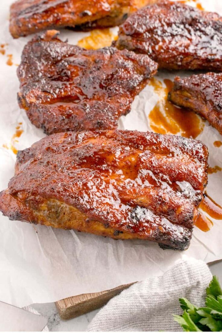 Barbecue glazed pork ribs on parchment paper.