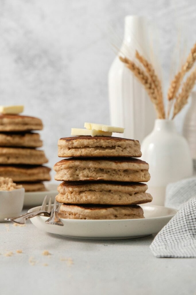 Stack of brown sugar pancakes with pats of butter on top.