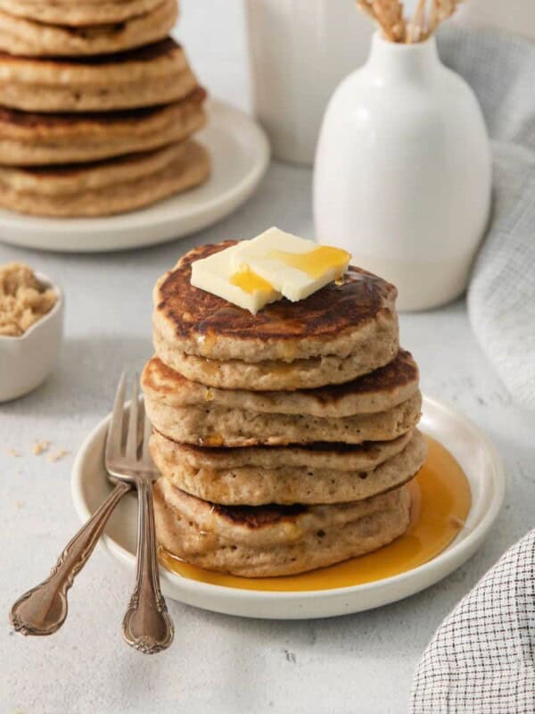 4 brown sugar pancakes on a plate, covered with syrup.