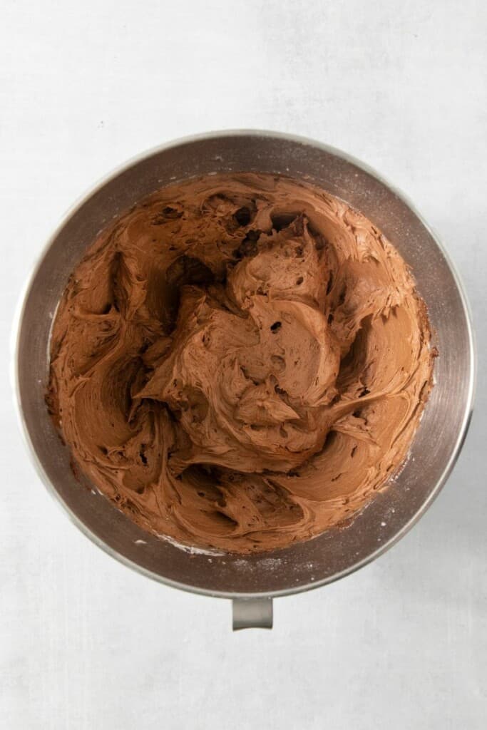 Whipped chocolate frosting in mixing bowl.