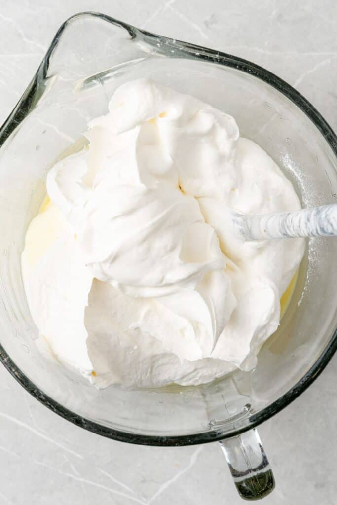 Whipped cool whip frosting inside a mixing bowl.
