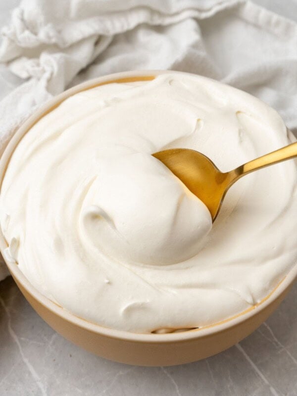Cool whip frosting being scooped up with a gold spoon.