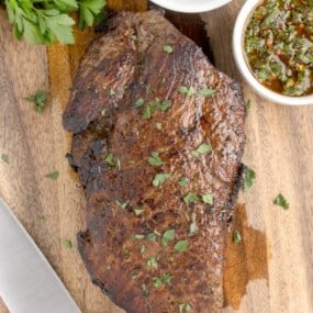London broil made in oven, displayed on wood cutting board.