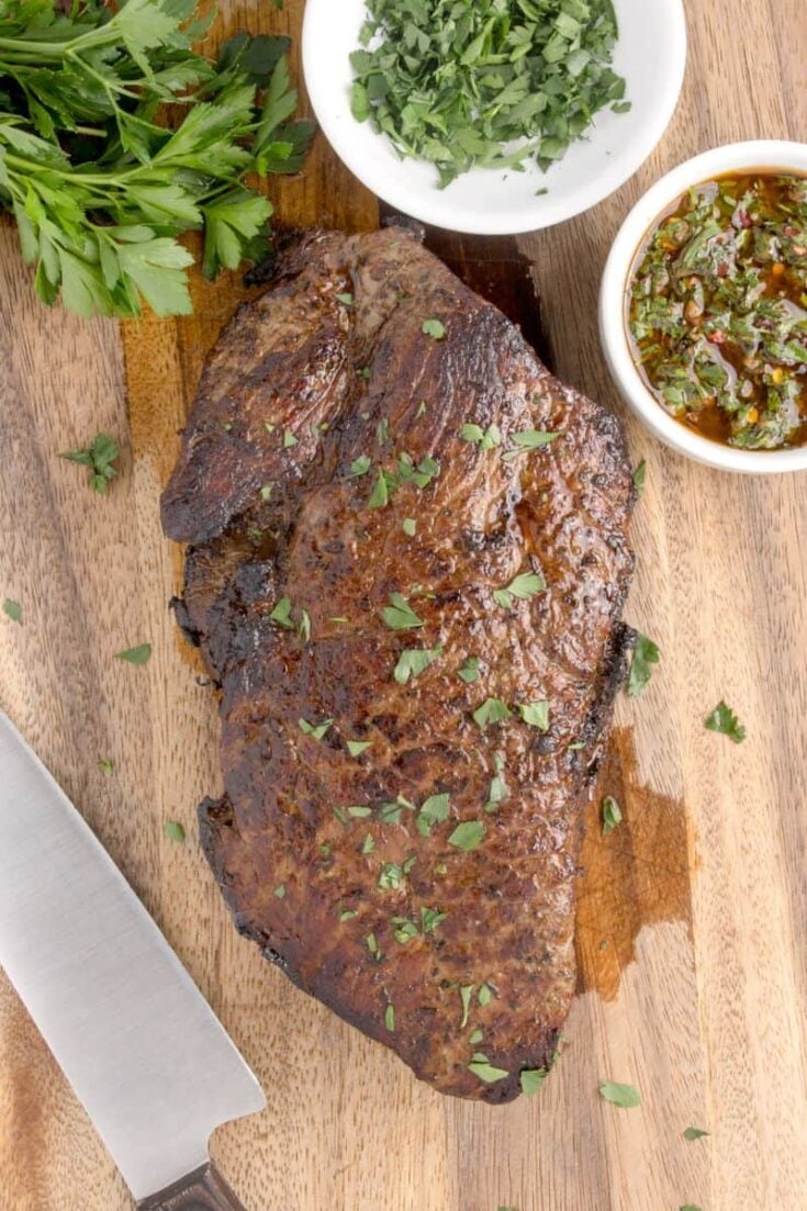 London broil made in oven, displayed on wood cutting board.