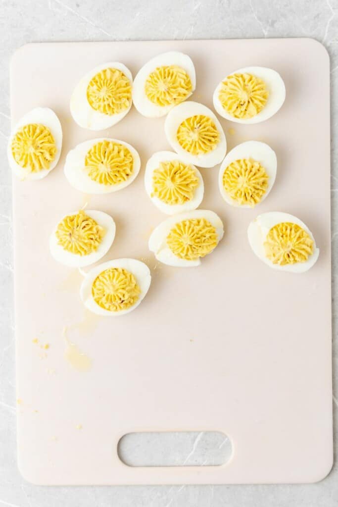 piping filling into halved hard boiled eggs 