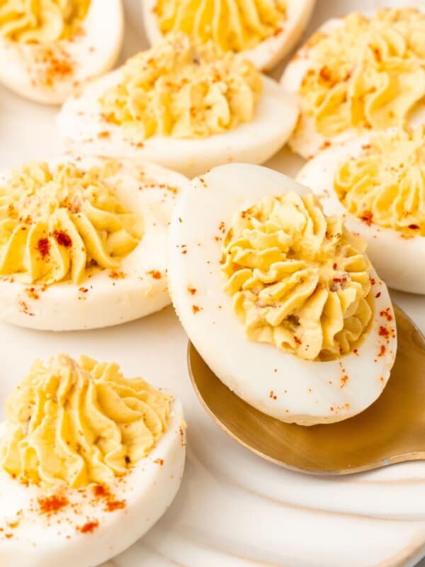 Very close up of the million dollar deviled eggs with a spoon picking one up.