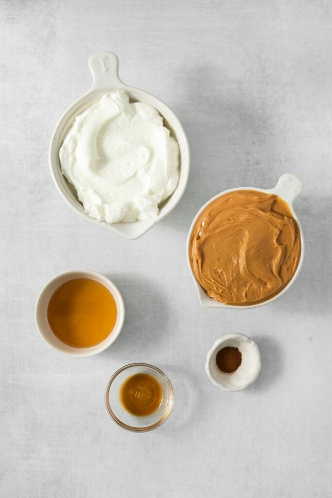 Ingredients needed to make peanut butter dip portioned out in small bowls.