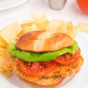 Fried pork chop sandwich with lettuce and tomato.