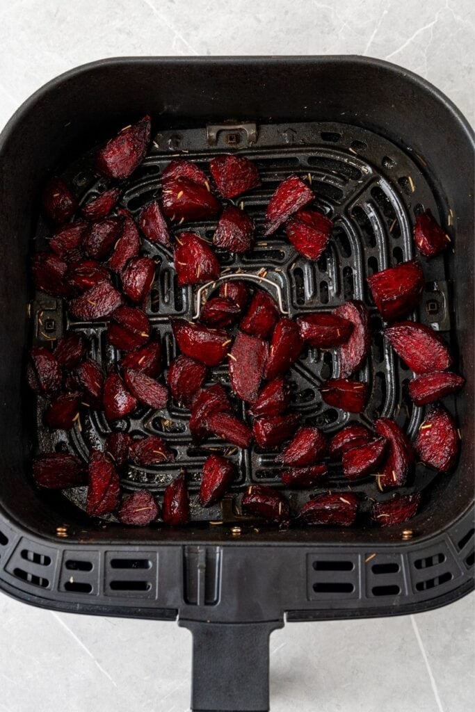 Cooked red beets in an air fryer basket.