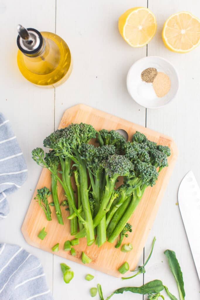 raw broccolinis on a cutting board