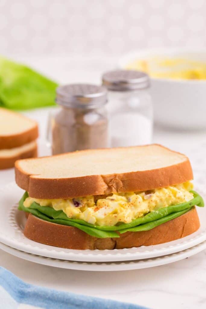 making an easy egg salad sandwich on a white plate