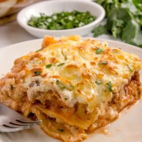 a slice of homemade italian lasagna on a white plate