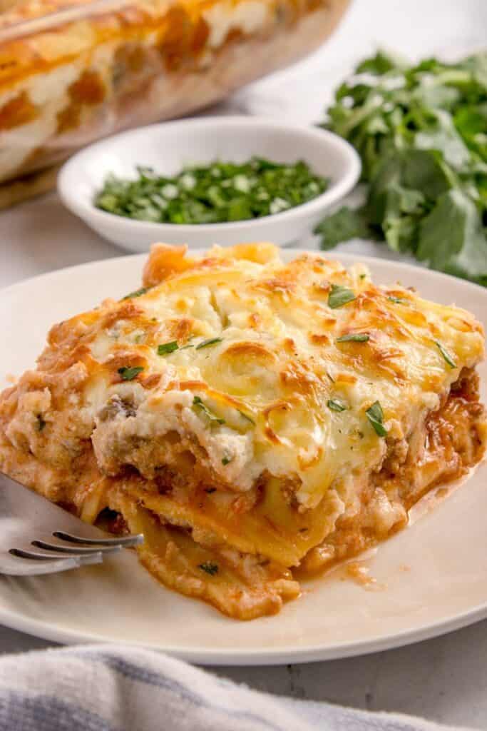 a slice of homemade italian lasagna on a white plate