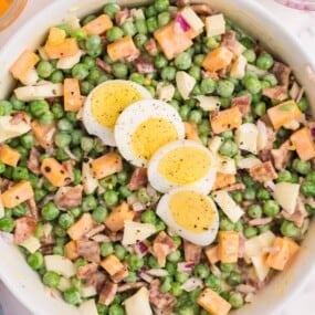 serving dish of pea salad with eggs and mayo