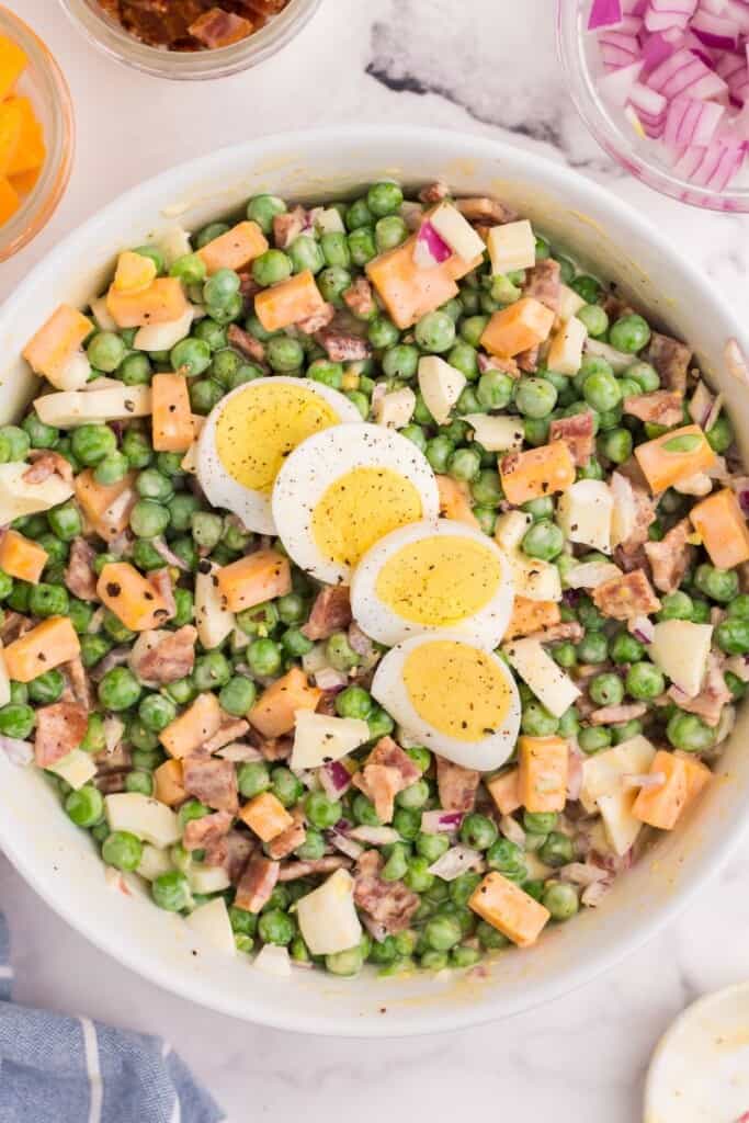 serving dish of pea salad with eggs and mayo