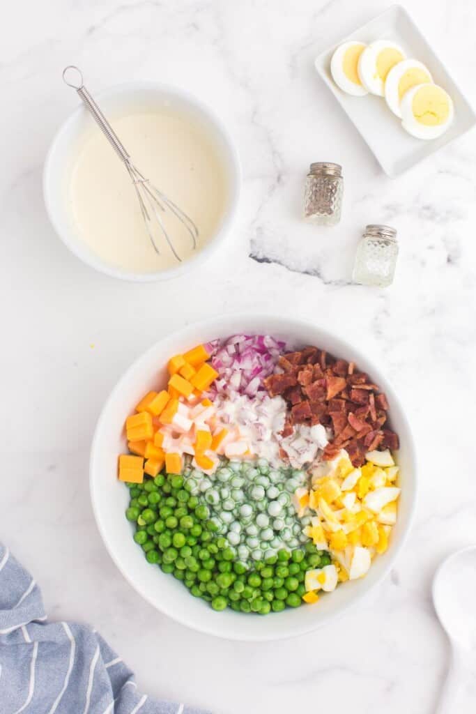 adding dressing to pea salad