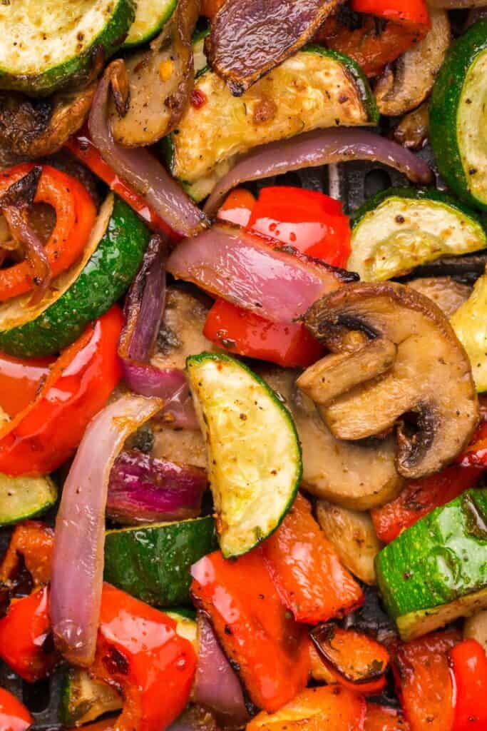 Close up of roasted air fried vegetables in the air fryer basket.