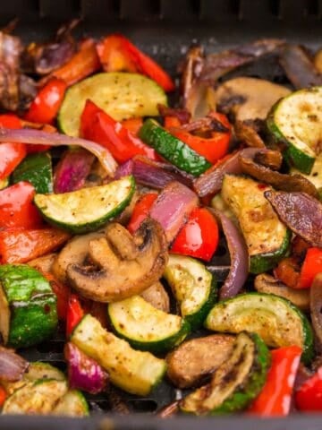 Air fryer vegetables in an air fryer basket.