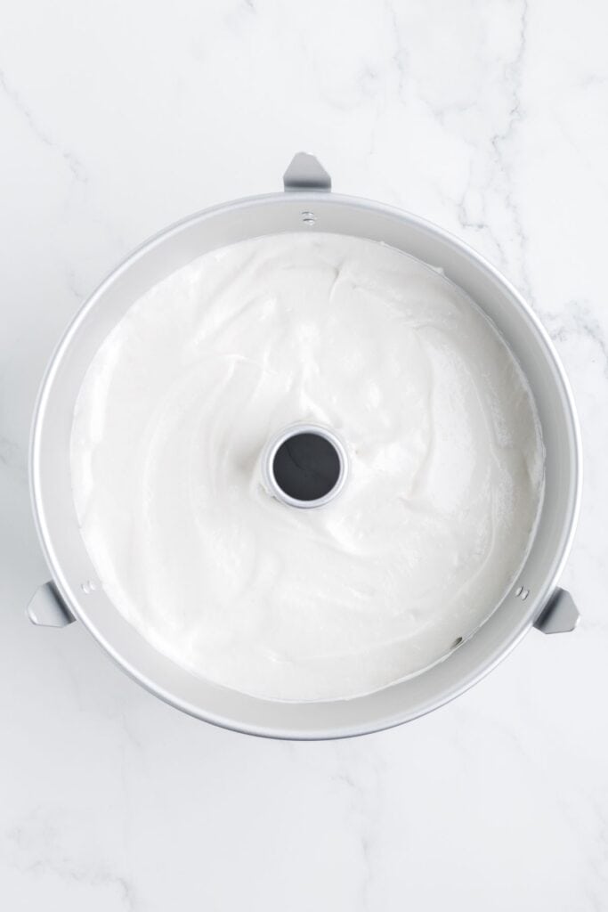 adding whipped cake batter to a bundt pan